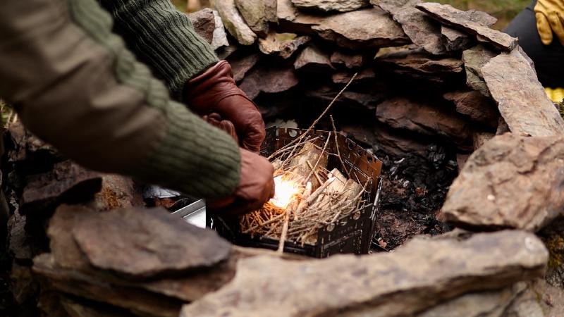 Lighting the fire at the stone fireplace with a panoramic view over the hills