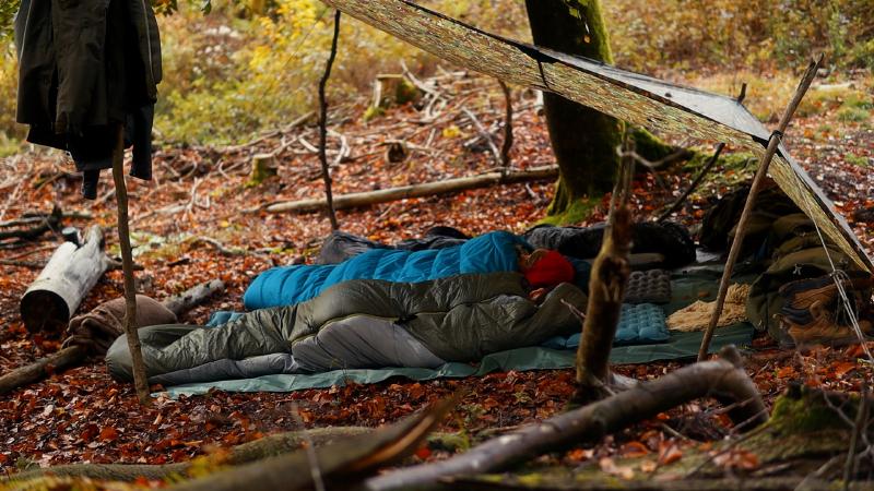 Sleeping bags under the tarp — night in the autumn forest