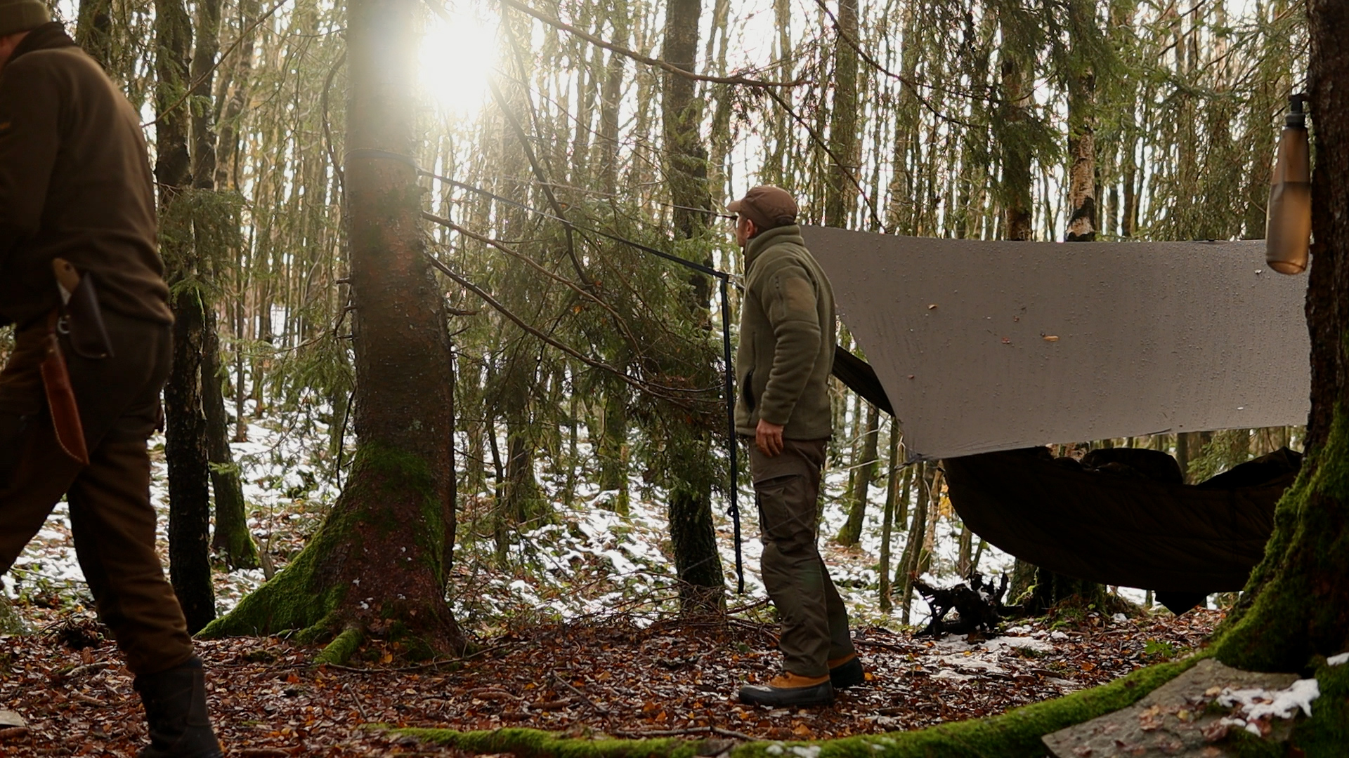 Aufgespanntes Tarp mit Hängematte im Morgenlicht des Winterwalds – Stefan und Simon beim Winterbiwak