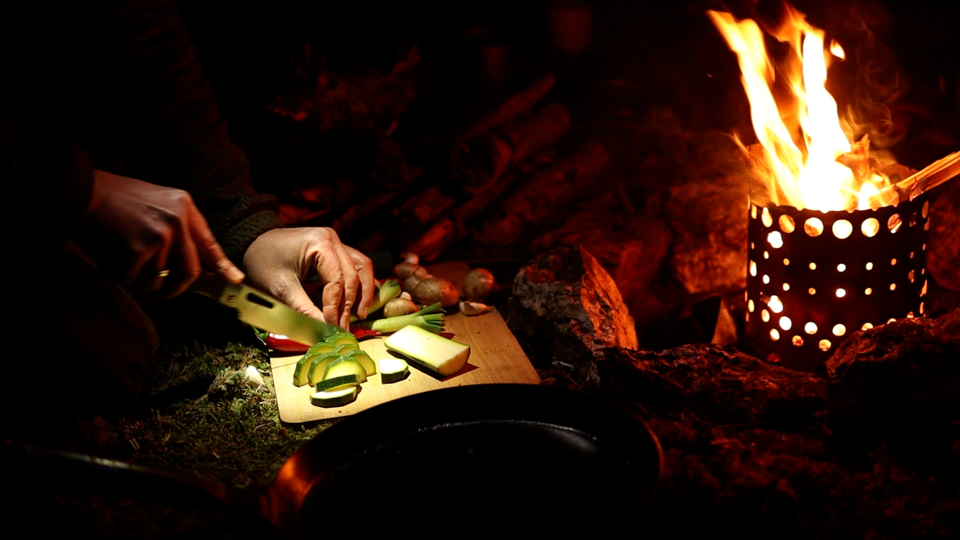 Gemüse schneiden am Lagerfeuer mit Hobo-Kocher beim Bushcraft-Camp