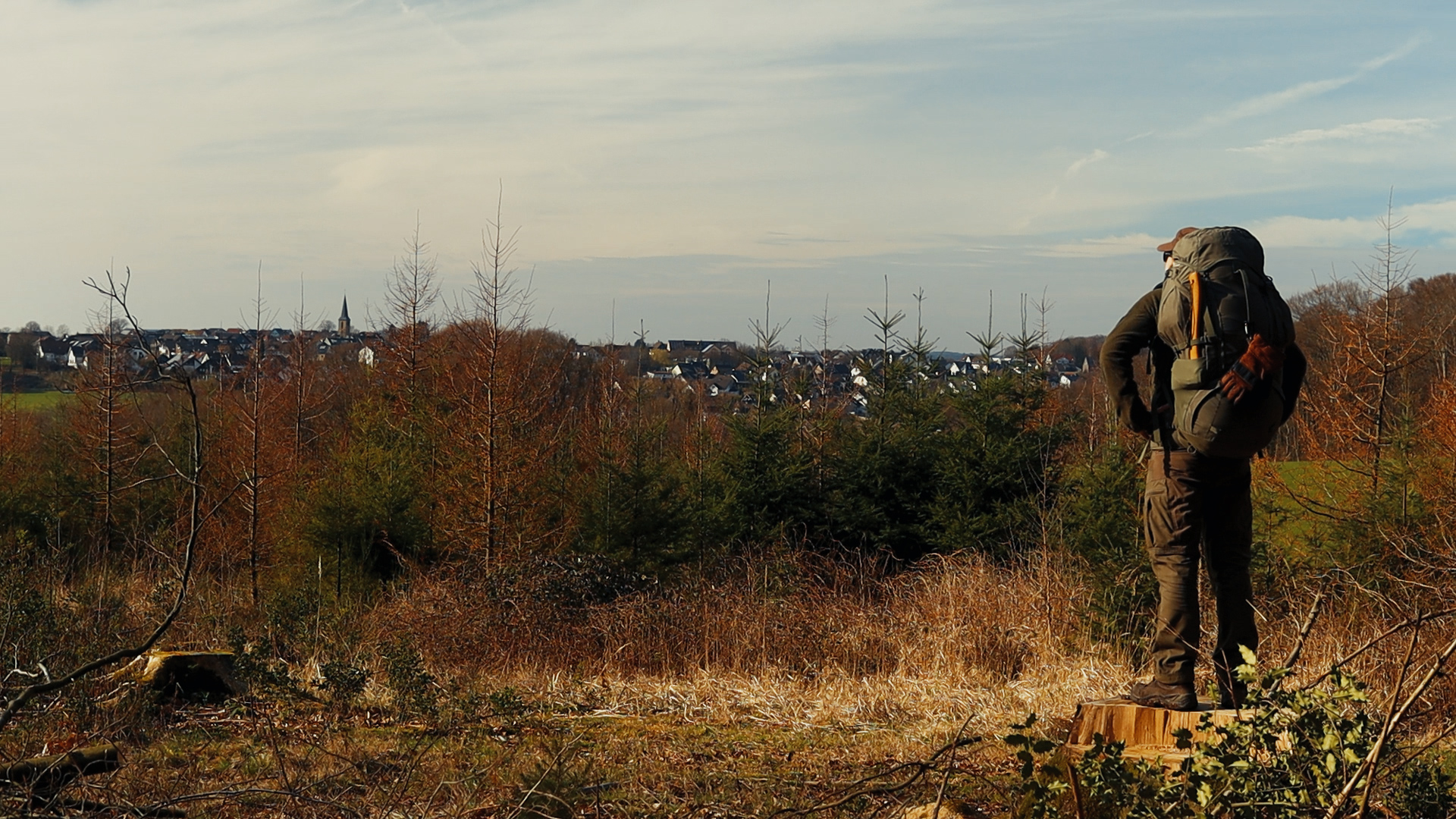 Simon Hilke mit Rucksack beim Einmarsch ins Revier, herbstlicher Laubwald im Hintergrund