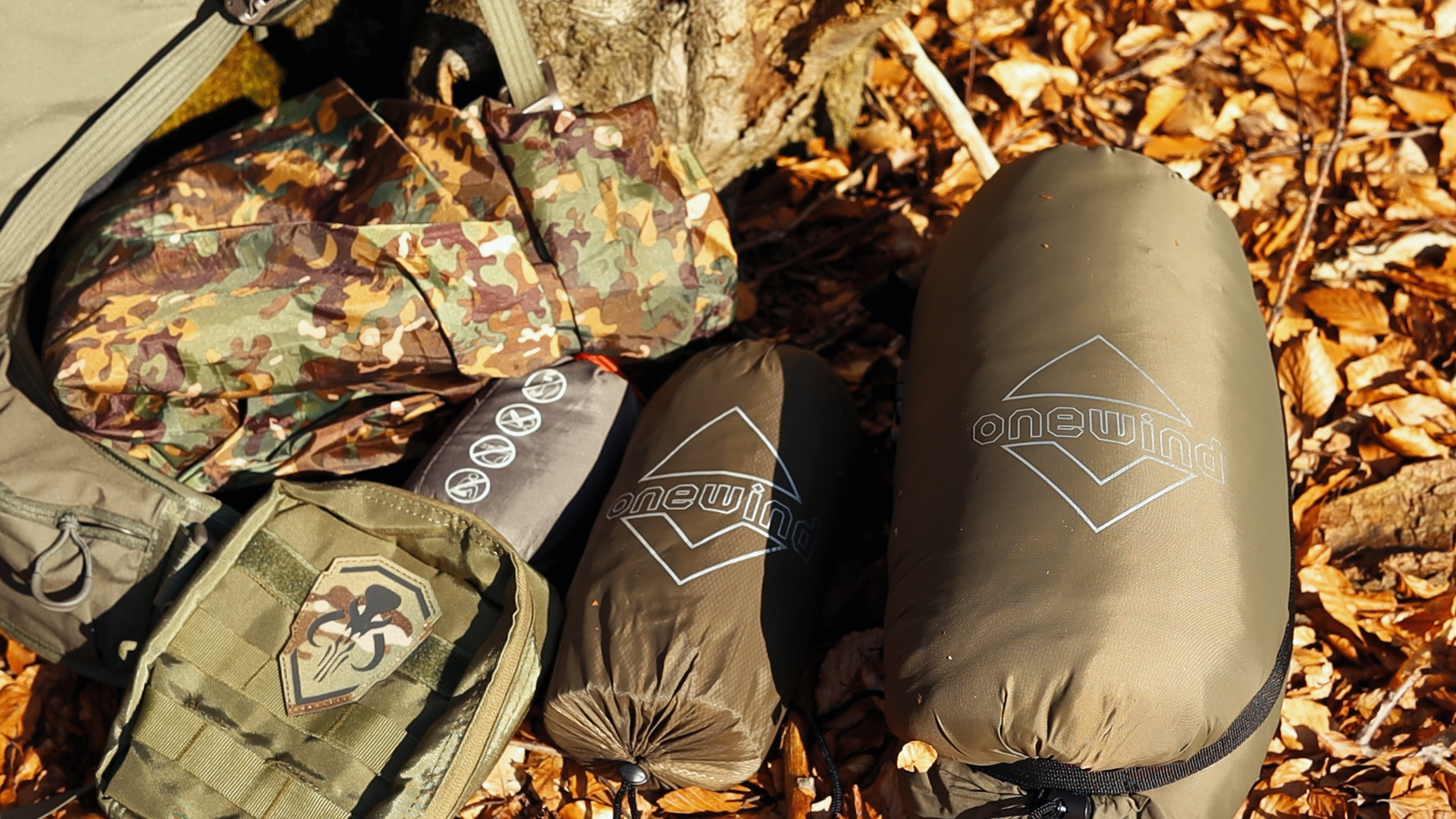 Packsäcke der onewind Doppellagen-Hängematte und des onewind Underquilts auf Herbstlaub