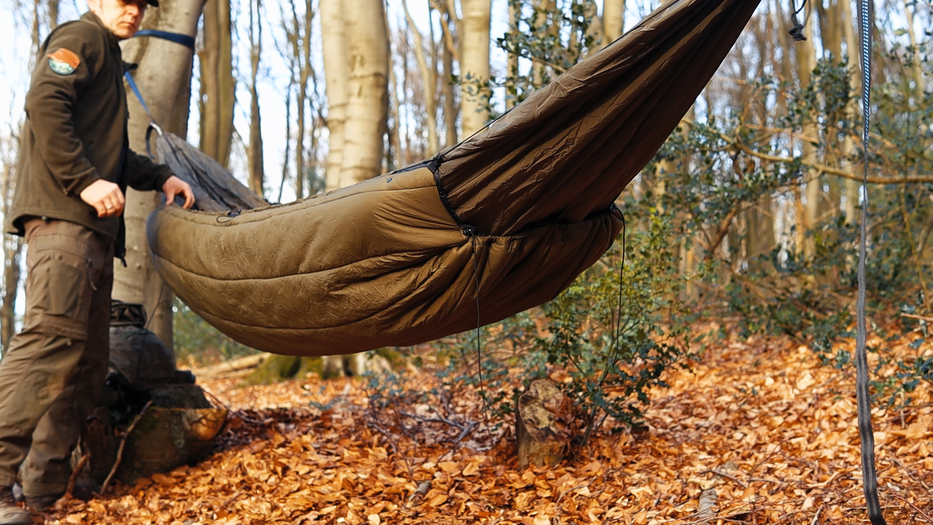 onewind Underquilt von der Seite an der aufgehängten Hängematte im Winterwald