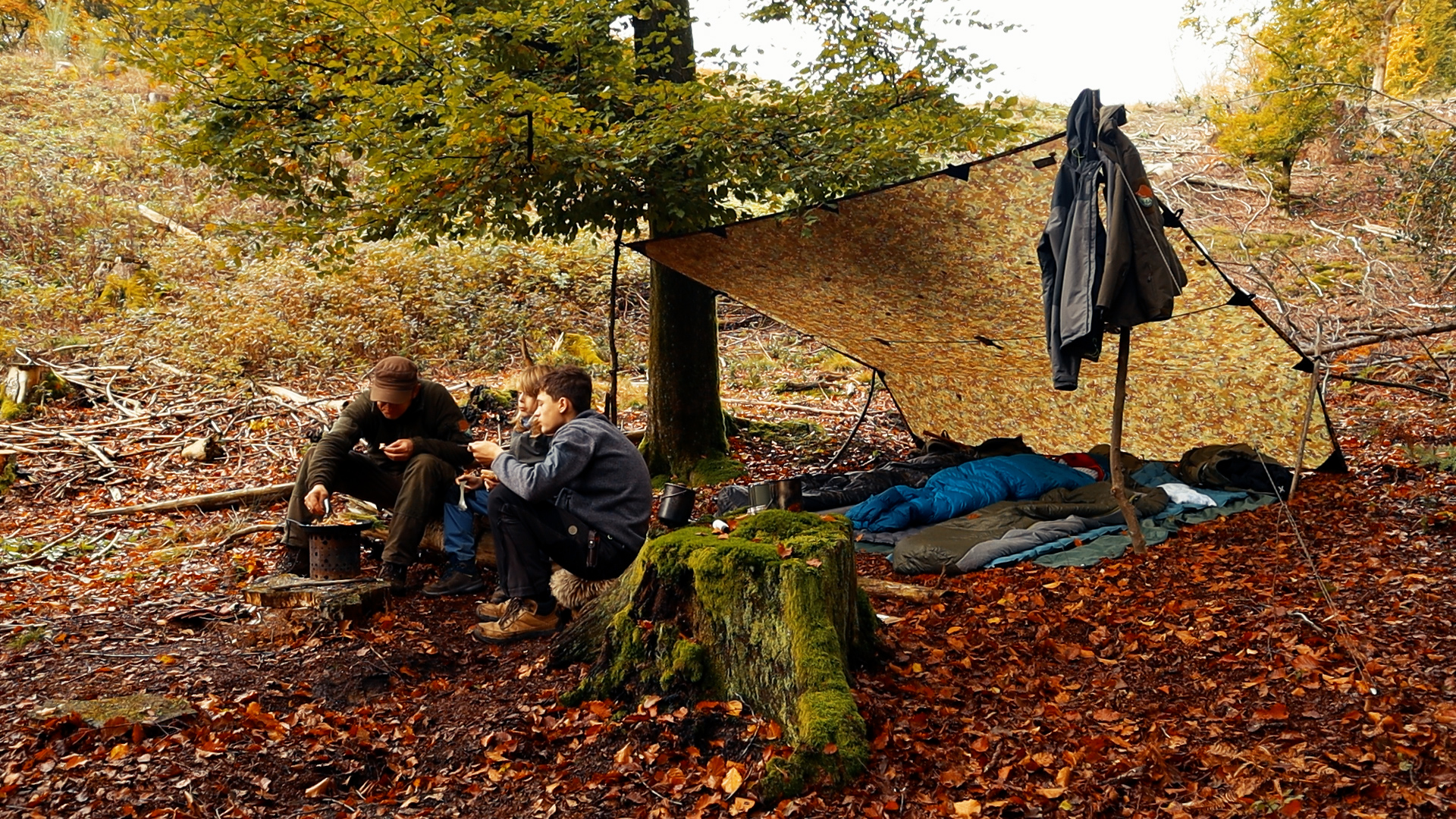 Morgen am Lagerplatz — Vater und Sohn am X-Fire, Schlafsäcke im Hintergrund