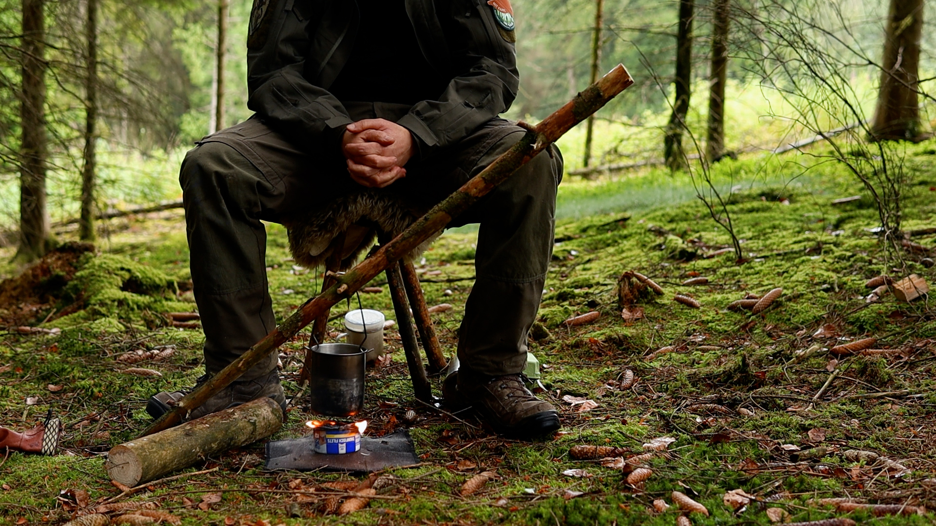 Topf auf dem selbstgebauten Thunfischdosen-Kocher über dem Feuer im Wald