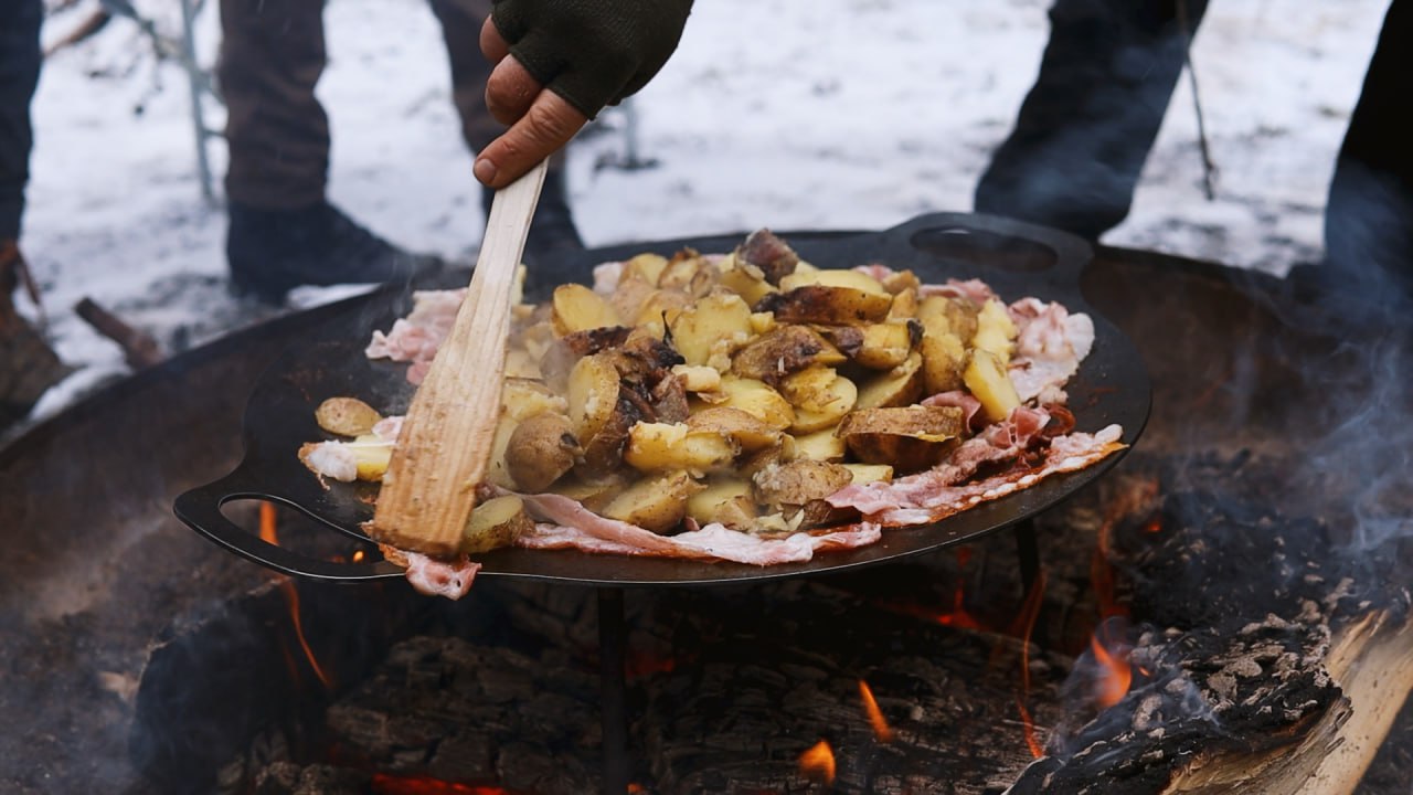 Bratkartoffeln mit Speck in der Jägerpfanne über der Glut beim Outdoorkochen auf der Schmidtburg