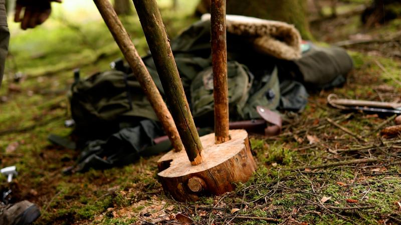 Der fertige Dreibein-Hocker steht im Moos