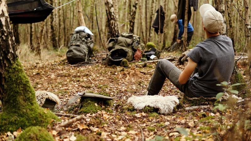 Eine Sitzbank aus Naturmaterial wird direkt im Wald gebaut