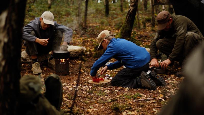 Das Abendessen wird im Wald über offenem Feuer gekocht